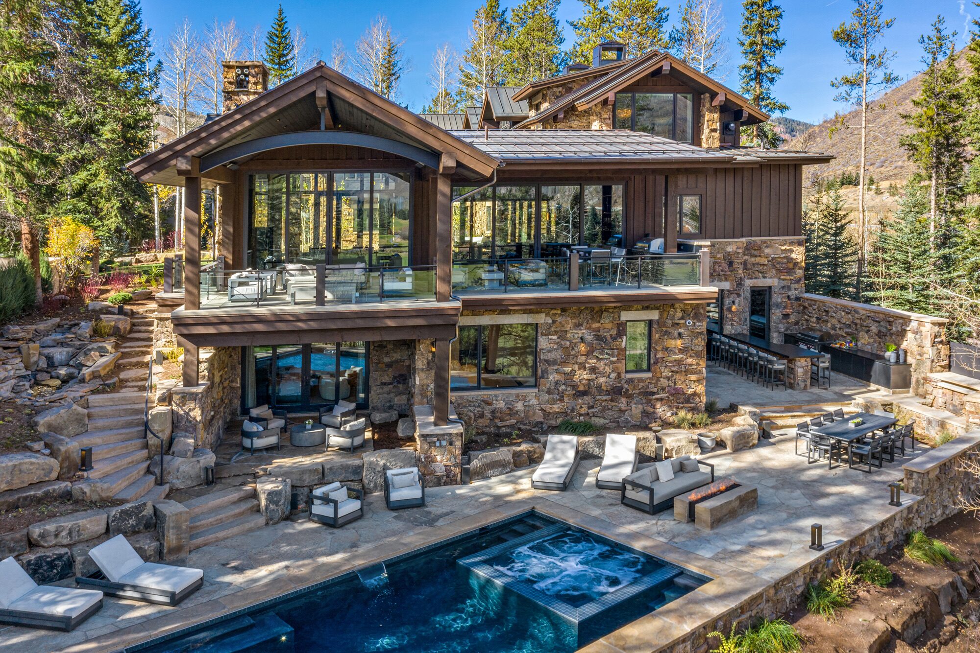Cabin Circle aerial view showcasing stone and timber exterior with pool and spa