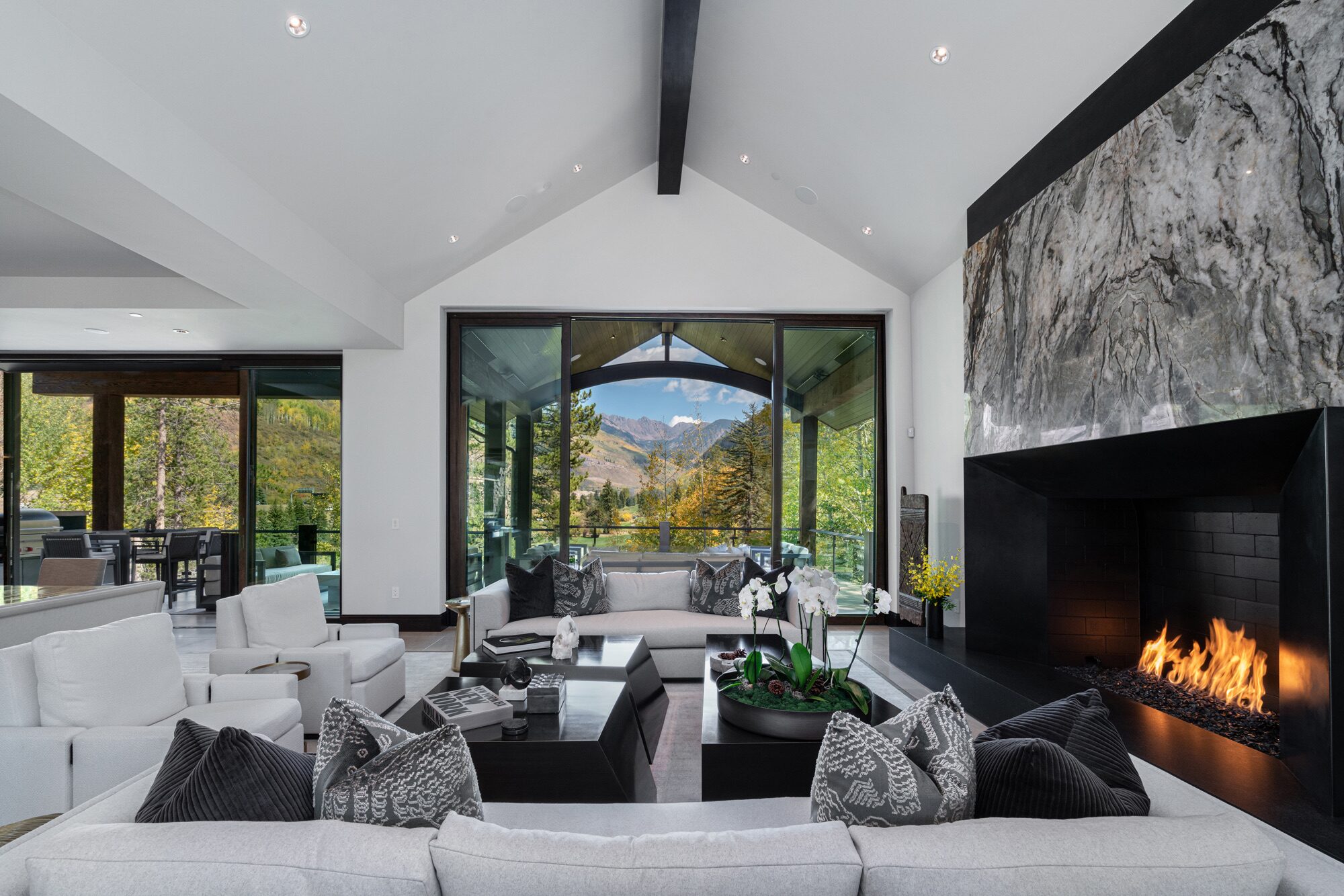 Great room with tempest blue quartzite fireplace and vaulted ceilings framing Gore Range views