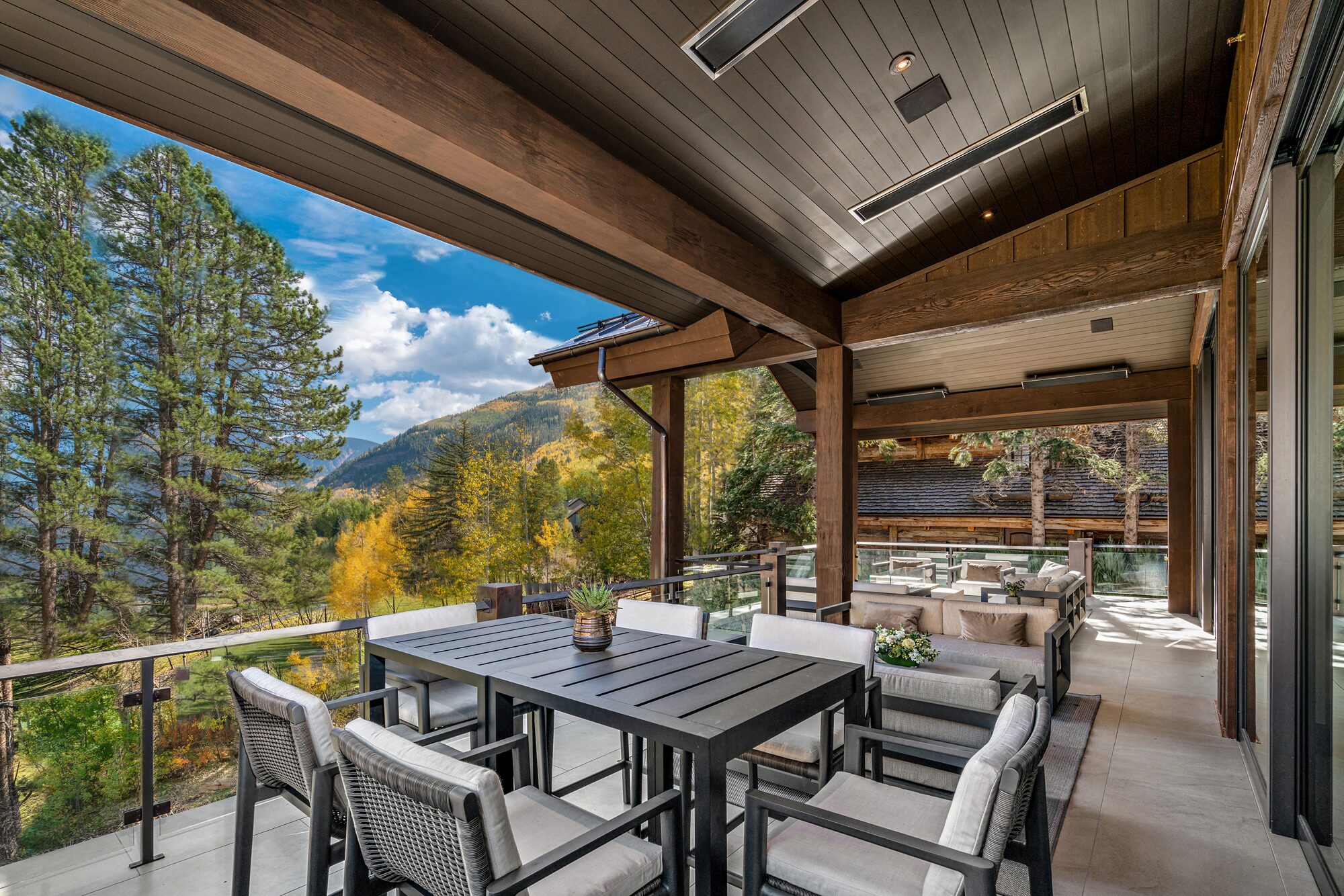 Covered deck dining area overlooking fall foliage and mountain landscape